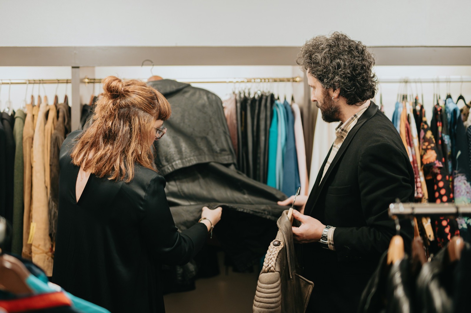 A stylist and client examining a jacket together